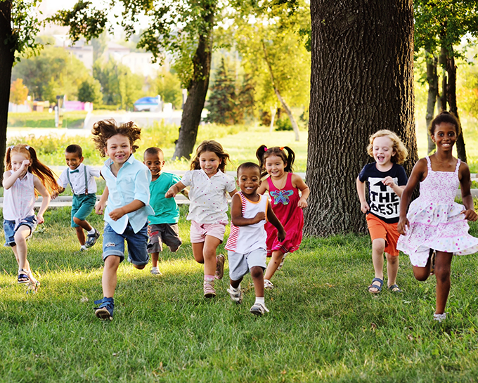 Several kids running in grass