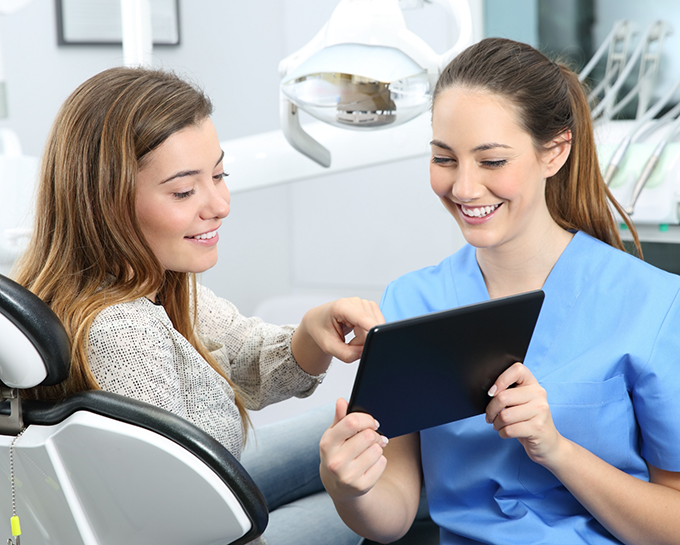 Orthodontic team member showing a tablet to a patient