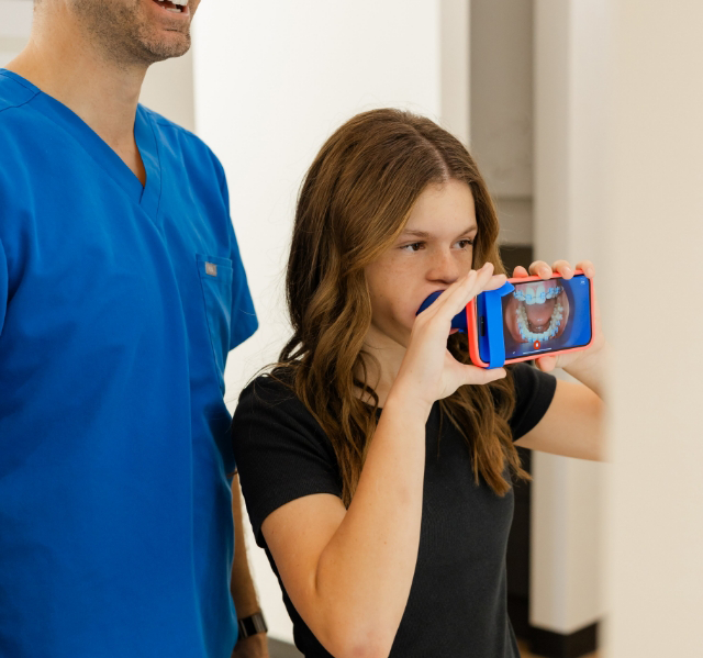 Orthodontist talking to a patient in the treatment chair about dental monitoring with Grin