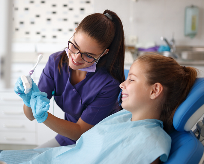 Orthodontist showing a model of the teeth to a teenage patient