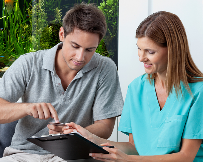 Orthodontic team member showing a tablet to an adult patient