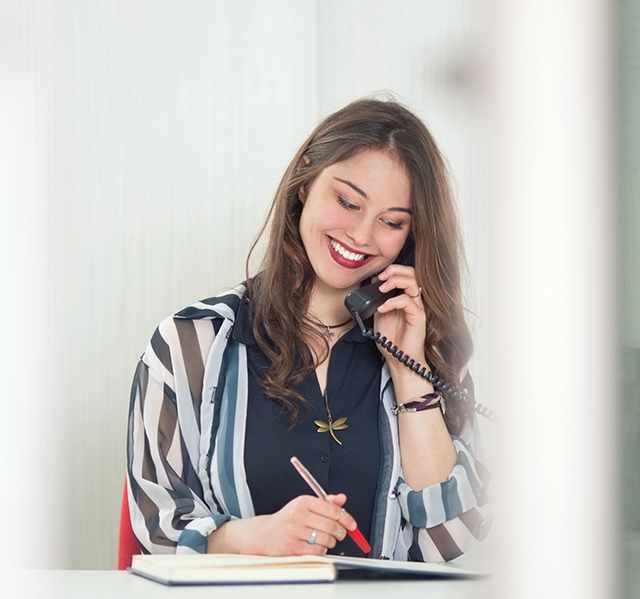 Woman smiling while talking on the phone with Gilbert orthodontic office