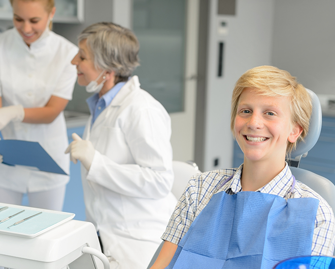 Teenage boy smiling in orthodontic treatment chair