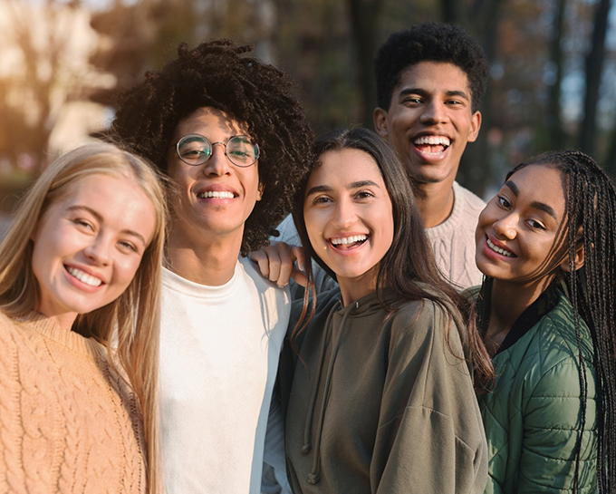 Five young adults smiling outdoors