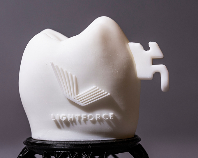 SMall white sculpture with the Light Force logo