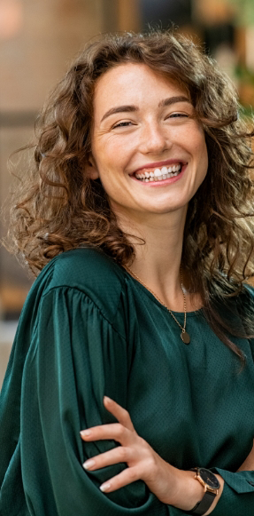 Smiling woman with curly brown hair and green blouse