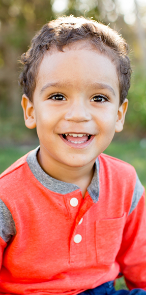 Smiling young boy in orange shirt