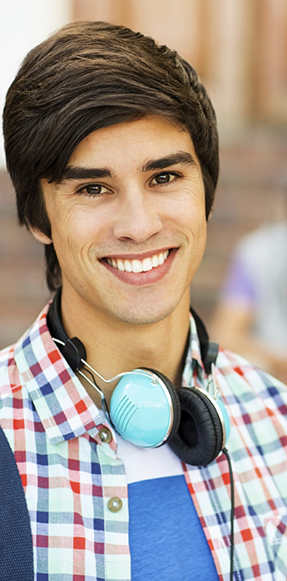 Smiling teenage boy with headphones around his neck