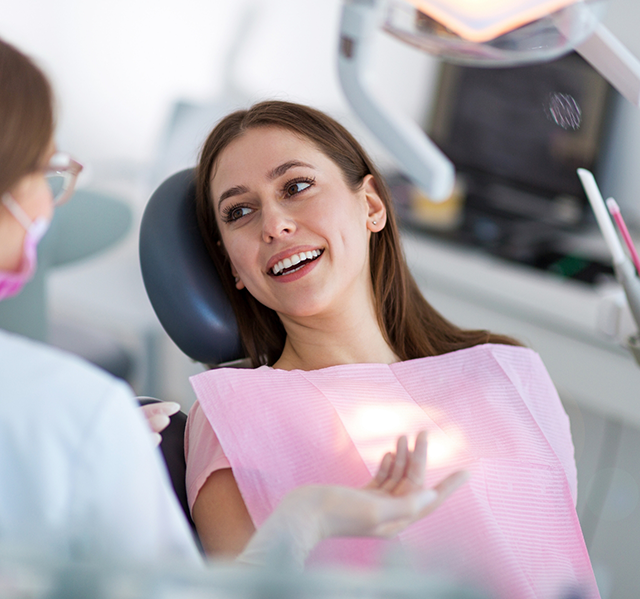 Woman in dental treatment chair talking to her orthodontist in Gilbert