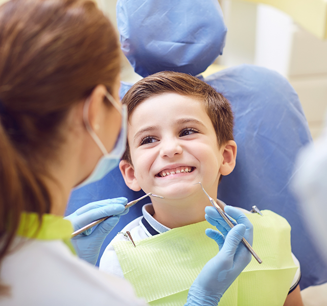 Young boy smiling in treatment chair during appointment for Phase 1 early orthodontics in Gilbert