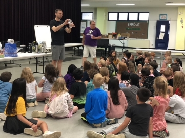 Doctor Larson giving a presentation to a classroom of kids