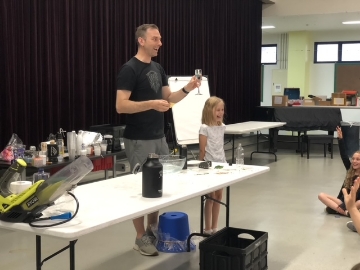 Doctor Larson holding a glass container during presentation